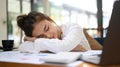 Woman office employee tired from work, does not have inspiration for work, with head lying on her arm at office desk Royalty Free Stock Photo