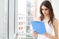 A woman in the office near the window, holding documents in her hands Royalty Free Stock Photo