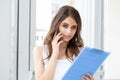 A woman in the office near the window, holding documents in her hands Royalty Free Stock Photo