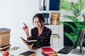 a business woman looks in a notebook in the office at a desk near books Royalty Free Stock Photo