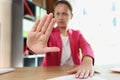 Woman in office shows gesture of refusal and disapproval.