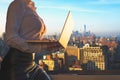 Woman in the office suit with a laptop on the balcony of the office building on the New York city background. Royalty Free Stock Photo