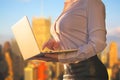 Woman in the office suit with a laptop on the balcony of the office building on the New York city background. Royalty Free Stock Photo