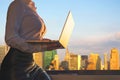 Woman in the office suit with a laptop on the balcony of the office building on the New York city background. Royalty Free Stock Photo