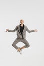 Woman, office worker in casual office style clothes meditating in a jump isolated over white studio background