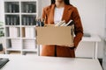 woman office worker celebrating her resignation, carrying her personal stuff. leaving job, changing or company.in nodern office Royalty Free Stock Photo