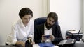 Woman, office worker shows important documents to her bearded boss who is busy with playing smart phone games in the