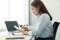 Woman office worker sitting to working and pressing a calculator to calculate the profit of a new business project