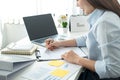 Woman office worker sitting to working and writing business project report on clipboard during checking information Royalty Free Stock Photo