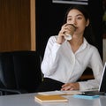 Woman office worker taking a coffee break at her workplace. Royalty Free Stock Photo