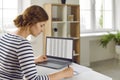 Woman office worker is working with spreadsheet on computers screens and making notes.