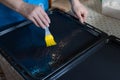 Woman oiling baking sheet. Baking at home.