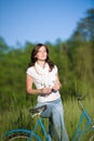 Woman with old-fashioned bike in summer meadow