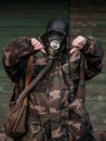 Woman with old gas mask and army jacket with a hood show thumb down. Concept - Nuclear Disarmament and Radiation Protection,