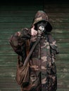 Woman with old gas mask and army jacket with a hood show thumb up. Concept - Nuclear Disarmament and Radiation Protection,