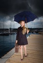 Woman with old suitcase and umbrella at harbor Royalty Free Stock Photo