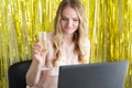 Woman on online corporate party or online dating with a laptop at the table drinks champagne from a glass. Internet celebration, Royalty Free Stock Photo