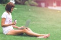 Woman online shopping concept. Woman in the green park with modern laptop. Bali island. Royalty Free Stock Photo