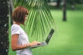Woman online shopping concept. Woman in the green park with modern laptop. Bali island. Royalty Free Stock Photo