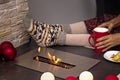 Woman at an open eco-friendly biofuel fireplace. No face, faceless. The concept of cosiness, comfort and warmth. Modern