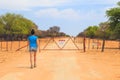 Woman open the gate on gravel road to Waterberg Plateau National Park, Namibia