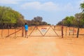 Woman open the gate on gravel road to Waterberg Plateau National Park, Namibia