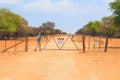 Woman open the gate on gravel road to Waterberg Plateau National Park, Namibia