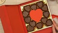 Woman open gift box with heart-shaped chocolate candies aphrodisiac, top view