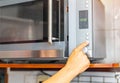 Woman open microwave in kitchen Royalty Free Stock Photo