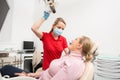 Woman with open mouth having her teeth examined by female dentist. Teeth checkup at dentist`s office.