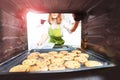 Woman open the oven to check fresh baked cookies Royalty Free Stock Photo