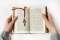 A woman opened an old bible in German. There is a crucifix on the book Royalty Free Stock Photo