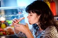 Woman opened the refrigerator and sniffs a container of food Royalty Free Stock Photo