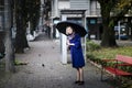 A woman opened an umbrella on an old town street.