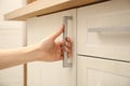 Woman opening cabinet door at home, closeup Royalty Free Stock Photo