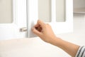 Woman opening cabinet door at home, closeup Royalty Free Stock Photo