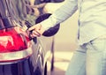 Woman opening car gas tank cap at petrol station Royalty Free Stock Photo