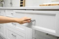 Woman opening drawer in kitchen, closeup view Royalty Free Stock Photo