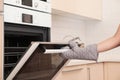 Woman opening electric oven door in kitchen Royalty Free Stock Photo