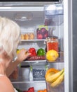 Woman opening fridge full of fresh food Royalty Free Stock Photo