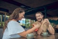 Woman opening gift and joyful man in cafe