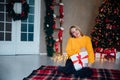 Beautiful woman opening gifts at christmas tree for new year Royalty Free Stock Photo