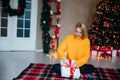 Beautiful woman opening gifts at christmas tree for new year Royalty Free Stock Photo