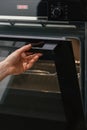 Woman opening glass door in empty electric oven Royalty Free Stock Photo