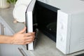 Woman opening microwave oven in kitchen Royalty Free Stock Photo