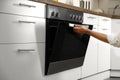 Woman opening modern electric oven in kitchen Royalty Free Stock Photo