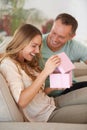 Woman opening present, man and happiness with surprise for birthday or anniversary, love and support with romance Royalty Free Stock Photo