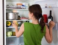 Woman opening refrigerator with food