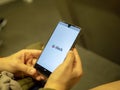 Woman opening Slack mobile communication app with logo on Android screen while commuting on subway train