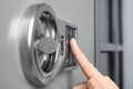 Woman opening steel safe with electronic lock